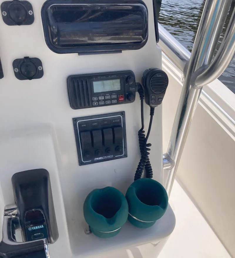 Slide: The Image of Control panel of a 2008 Cobia 256 Center Console boat with radio and cup holders. - 25