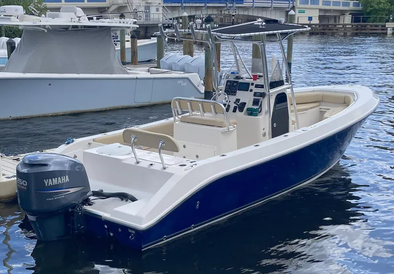 Slide: The Image of 2008 Cobia 256 Center Console boat docked, featuring a Yamaha outboard motor. - 4