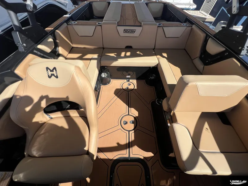 Slide: The Image of 2024 Heyday WT Surf boat interior with tan seating and wood flooring. - 2