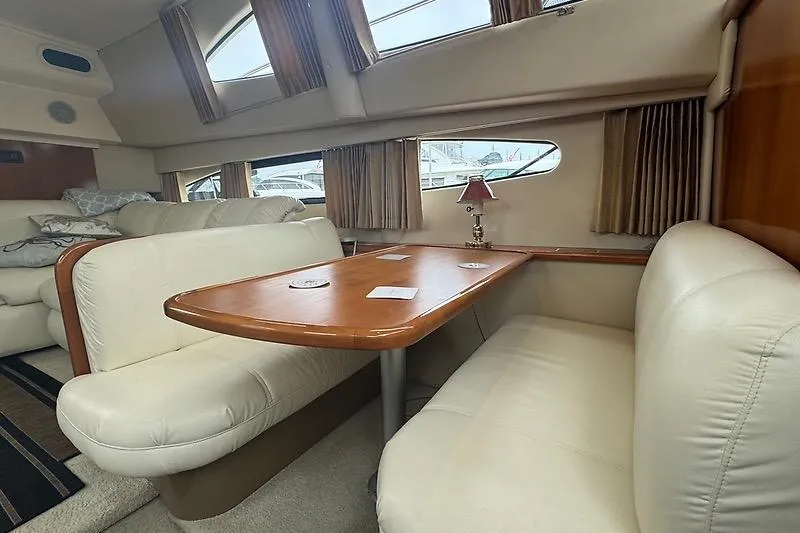 Slide: The Image of Interior of 2004 Carver 366 Motor Yacht with plush seating and wooden table. - 19