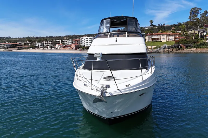 Slide: The Image of 2004 Carver 366 Motor Yacht on serene water with coastal backdrop. - 5