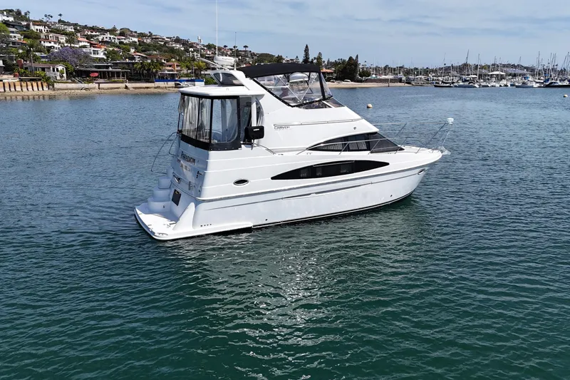 Slide: The Image of 2004 Carver 366 Motor Yacht on calm water near a coastal town. - 6