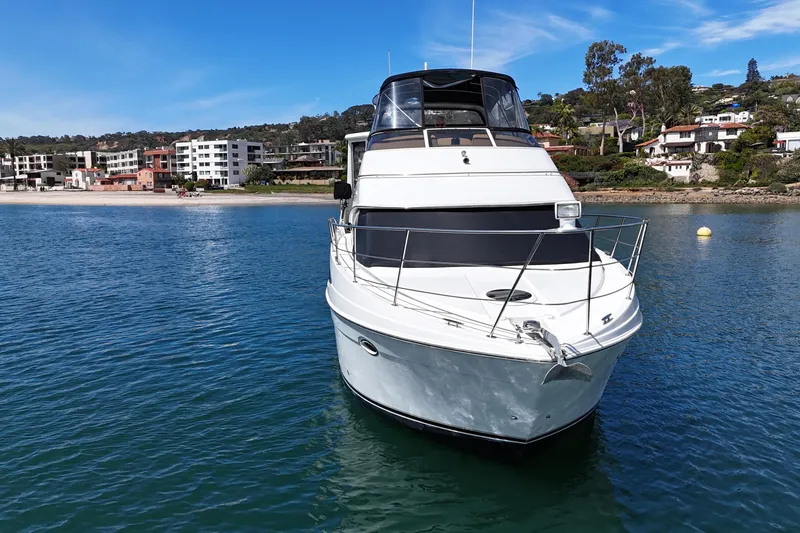 Slide: The Image of 2004 Carver 366 Motor Yacht on calm water near a scenic shoreline. - 7