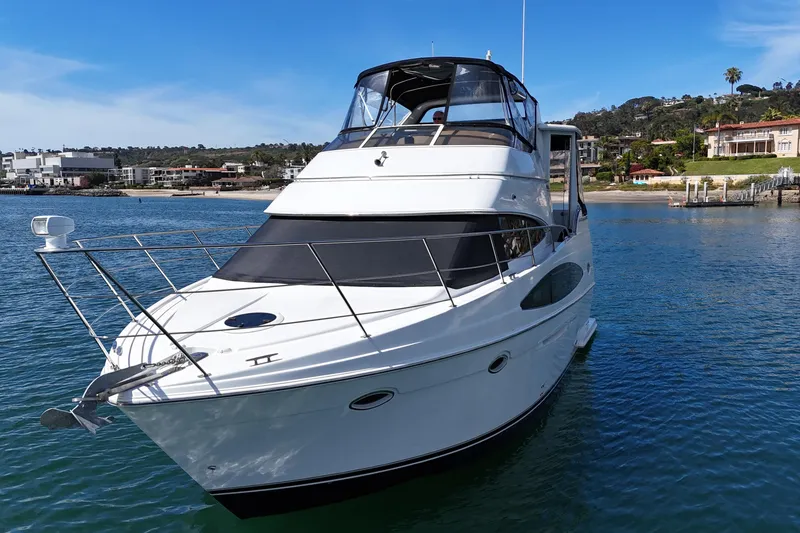 Slide: The Image of 2004 Carver 366 Motor Yacht on calm water, with scenic coastal background. - 8