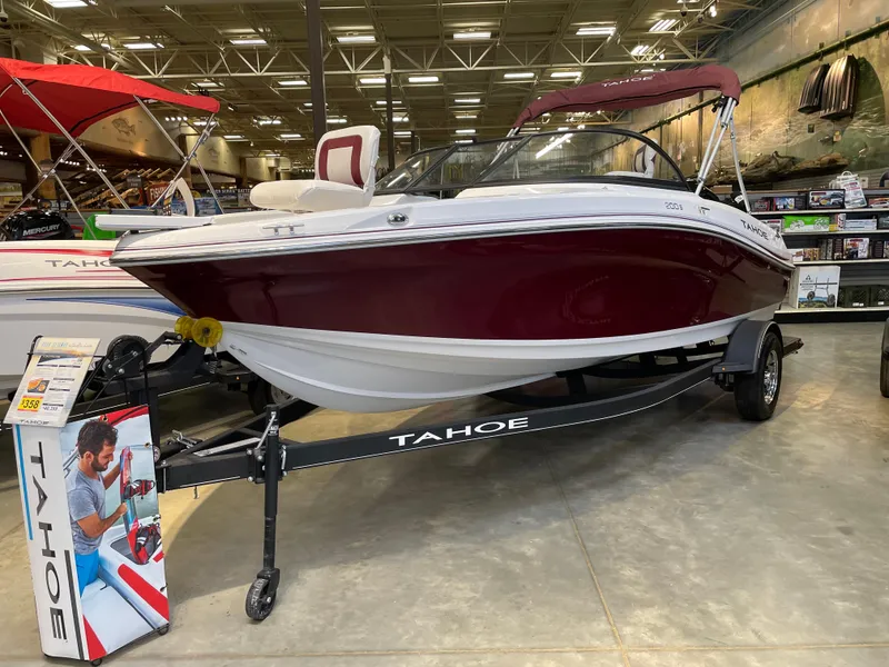 Slide: The Image of 2024 Tahoe 200 S boat on display in showroom with maroon and white design. - 0