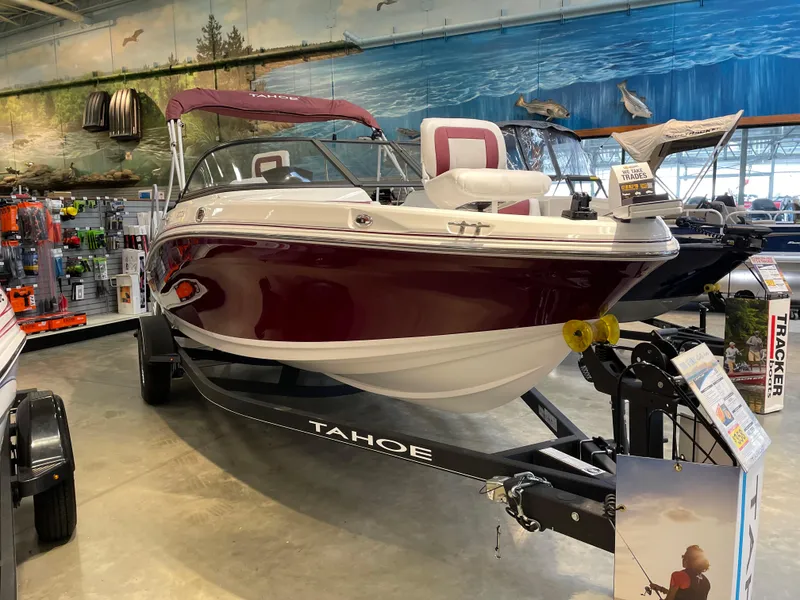 Slide: The Image of 2024 Tahoe 200 S boat displayed indoors, featuring a sleek maroon and white design. - 1