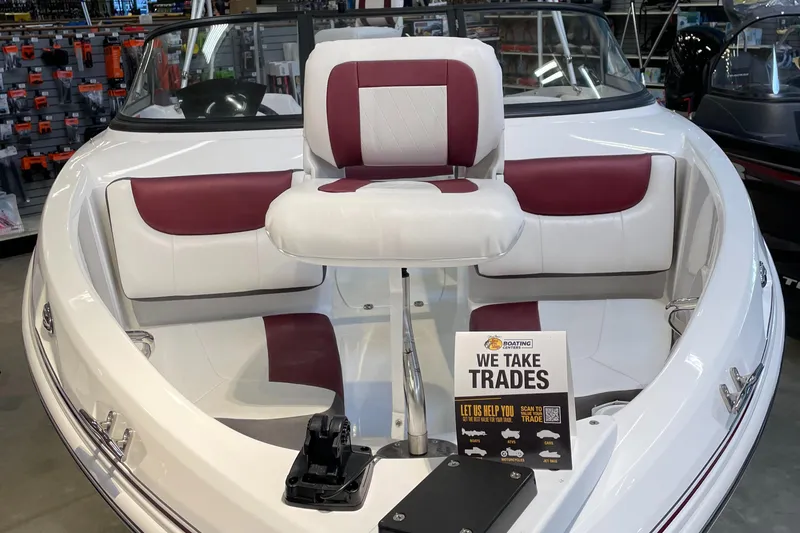 Slide: The Image of 2024 Tahoe 200 S boat interior with red and white seating, trade-in sign displayed. - 2