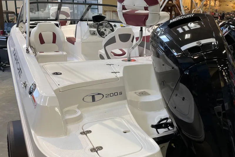 Slide: The Image of 2024 Tahoe 200 S boat with Mercury engine, white and maroon interior, in showroom. - 4