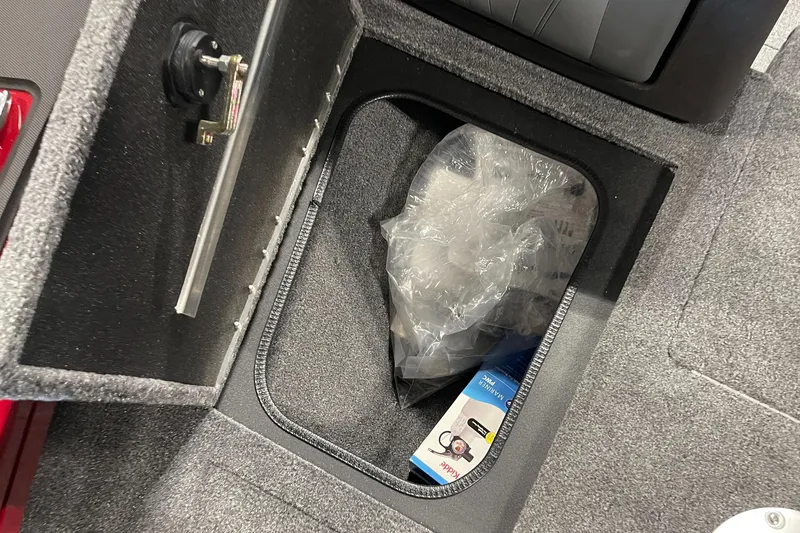 Slide: The Image of Storage compartment in 2024 Tracker Targa V-19 WT boat, featuring carpeted interior and accessories. - 18