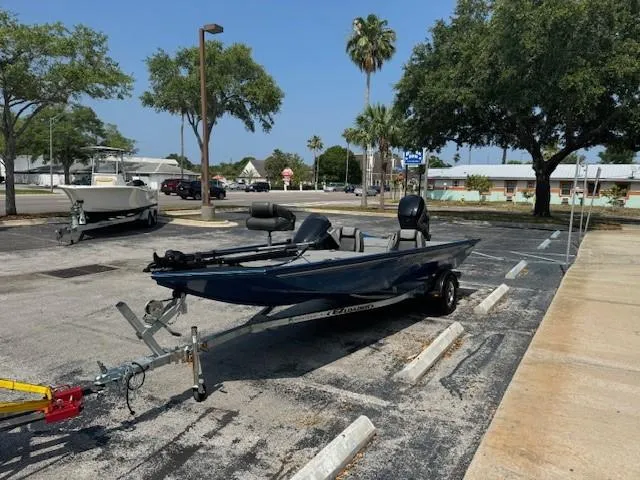 Slide: The Image of 2021 Lund 1875 Renegade boat on trailer in parking lot with trees and buildings. - 5