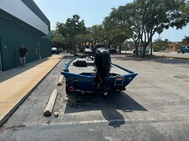 Slide: The Image of 2021 Lund 1875 Renegade boat parked in a lot near trees and a building. - 6