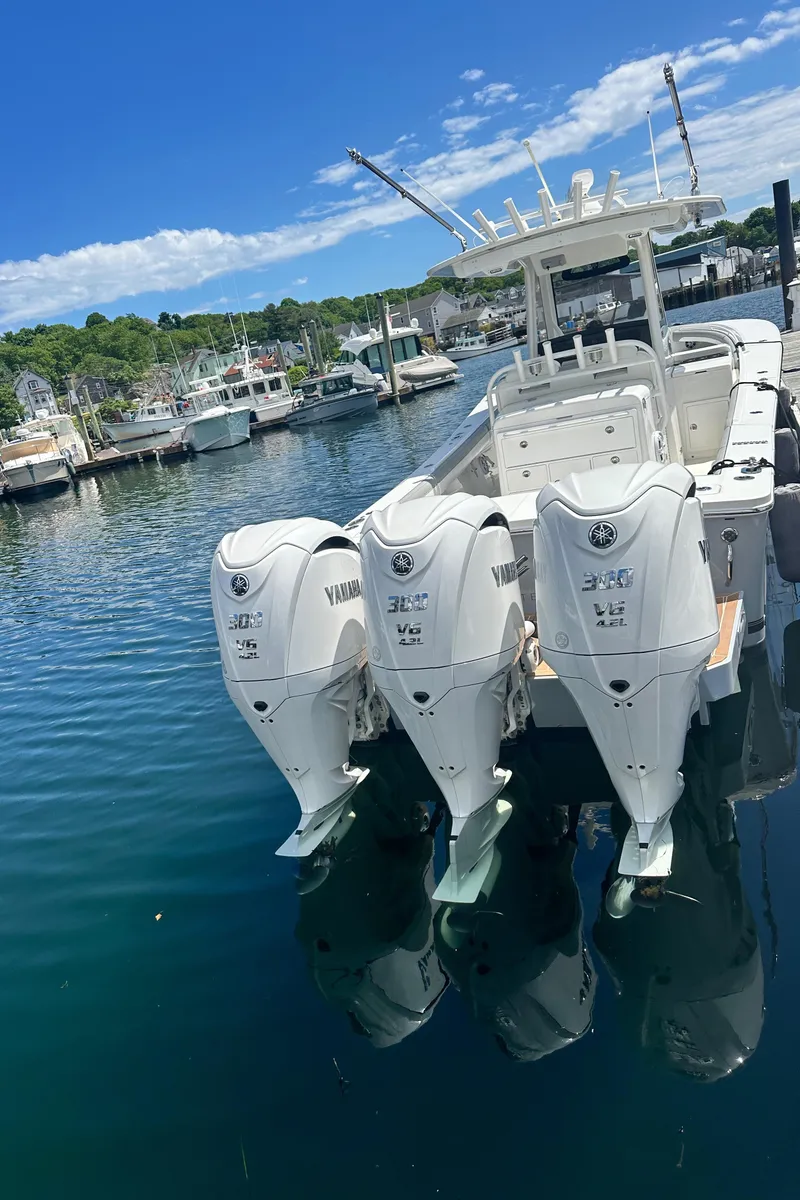 Slide: The Image of 2022 Regulator 34 boat with triple Yamaha engines docked in a marina. - 13