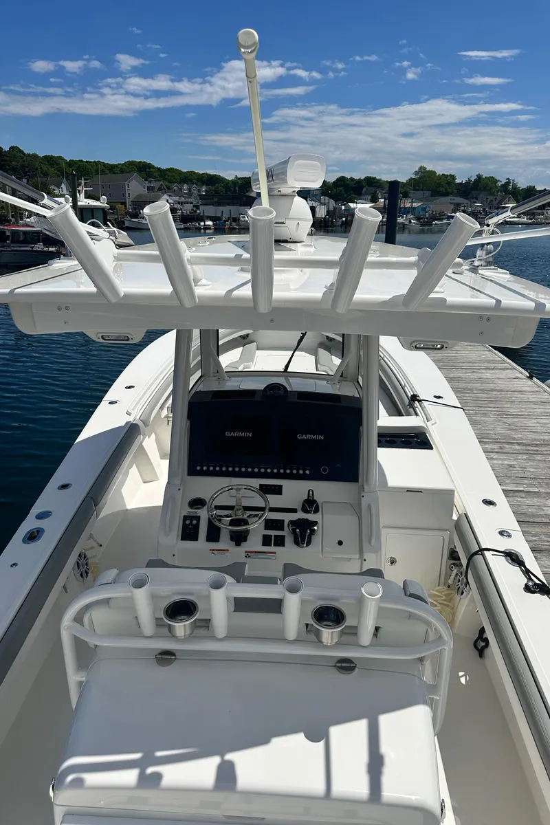 Slide: The Image of 2022 Regulator 34 boat docked, featuring a modern control panel and rod holders. - 14