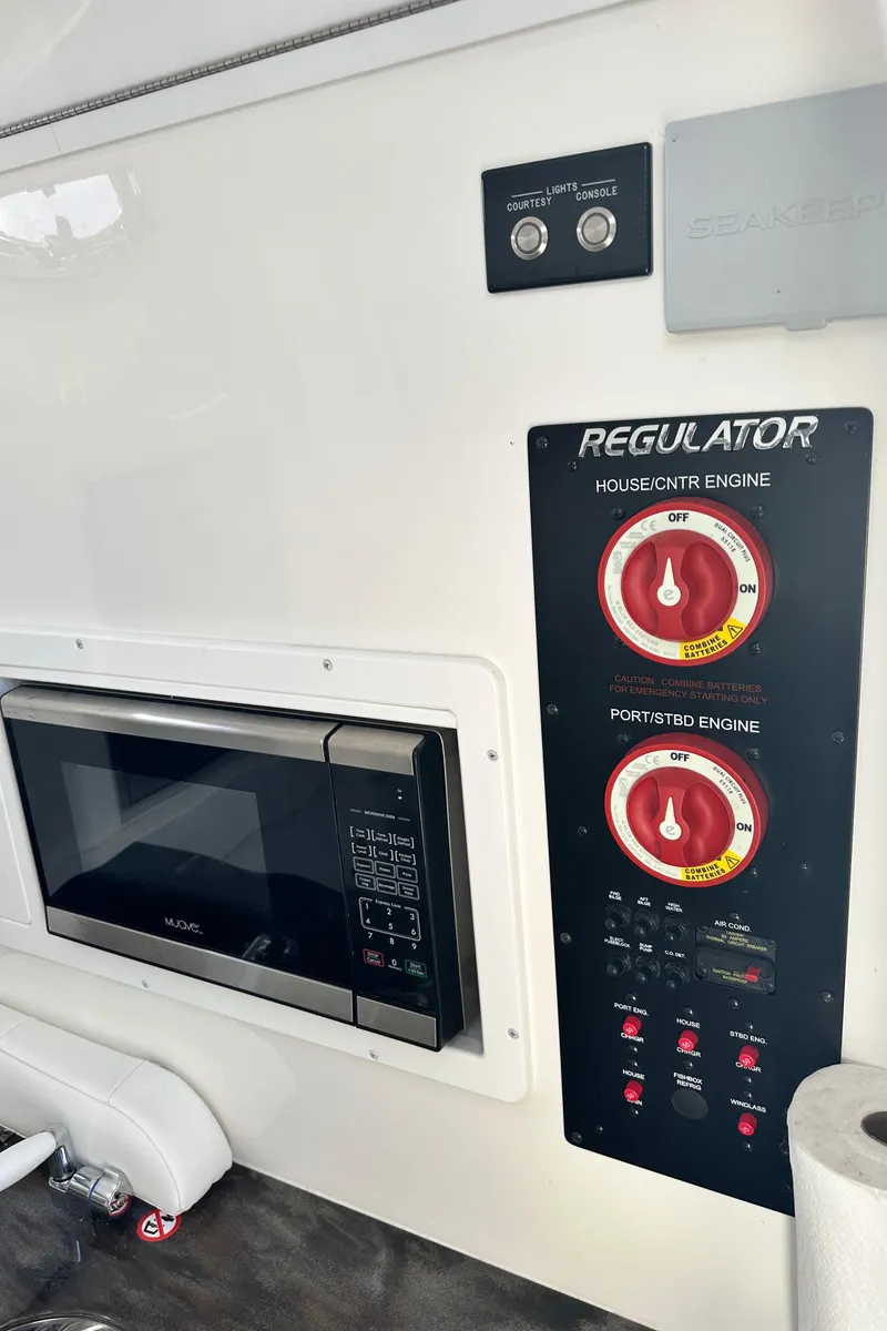 Slide: The Image of 2022 Regulator 34 boat interior with control panel and microwave. - 15