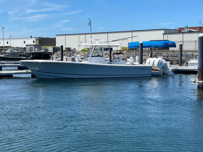 Slide: The Image of 2022 Regulator 34 boat docked at marina with clear blue sky. - 2