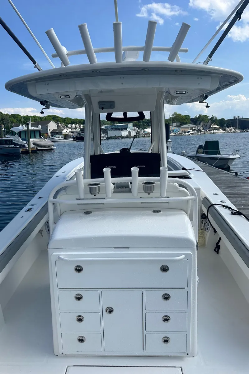 Slide: The Image of 2022 Regulator 34 boat docked, featuring a spacious deck and rod holders. - 22