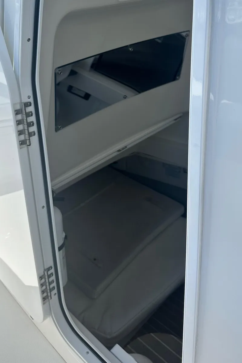 Slide: The Image of 2022 Regulator 34 boat interior storage compartment with open door. - 6