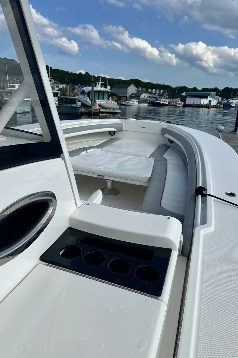 Slide: The Image of 2022 Regulator 34 boat with sleek design, docked at a marina under a partly cloudy sky. - 16