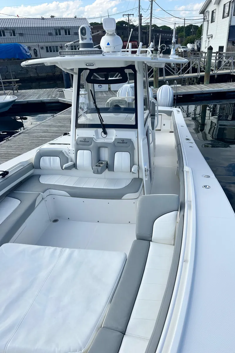 Slide: The Image of 2022 Regulator 34 boat docked, featuring spacious seating and modern design. - 18
