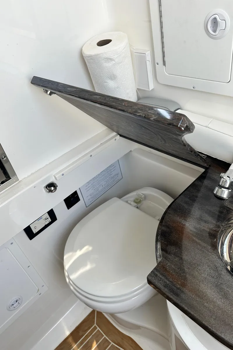Slide: The Image of 2022 Regulator 34 boat bathroom with toilet, sink, and storage. - 23