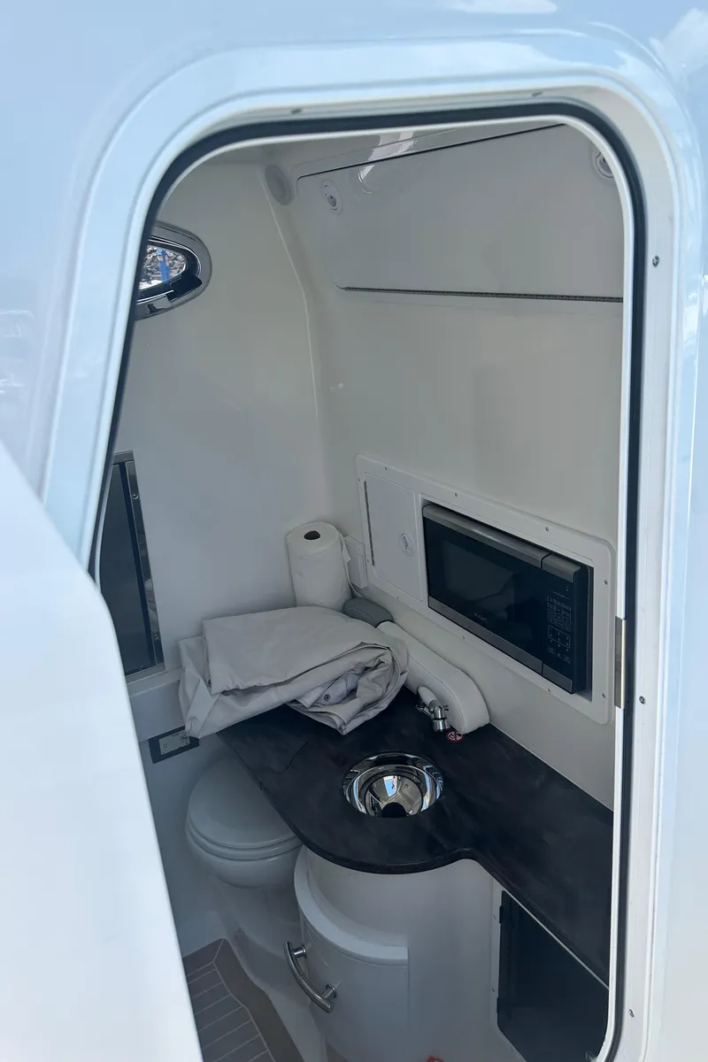 Slide: The Image of 2022 Regulator 34 boat interior with compact kitchenette and storage. - 7