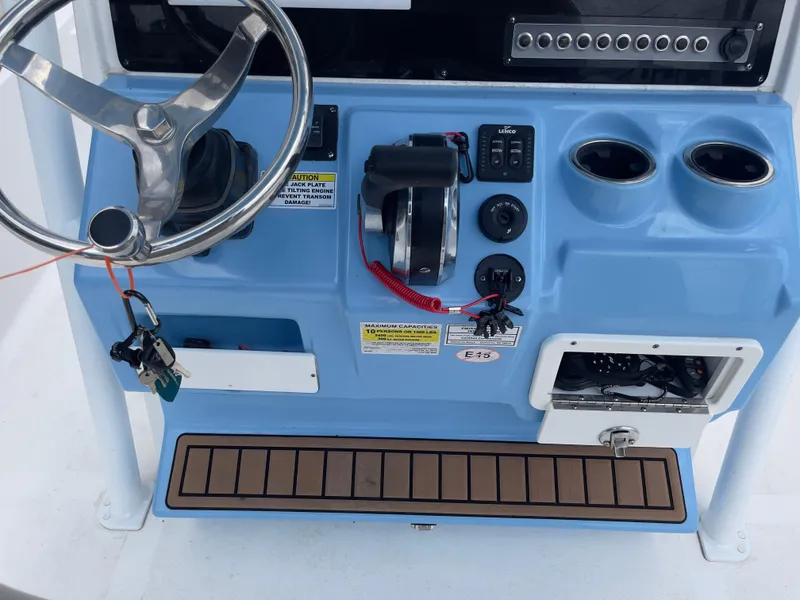 Slide: The Image of 2019 Tidewater 2410 Bay Max boat console with steering wheel, controls, and storage compartments. - 23