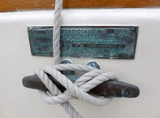 Slide: The Image of Plaque on 1961 Rhodes Swiftsure boat with rope tied around cleat. - 13
