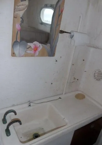 Slide: The Image of 1961 Rhodes Swiftsure boat bathroom with sink, mirror, and toilet paper holder. - 17