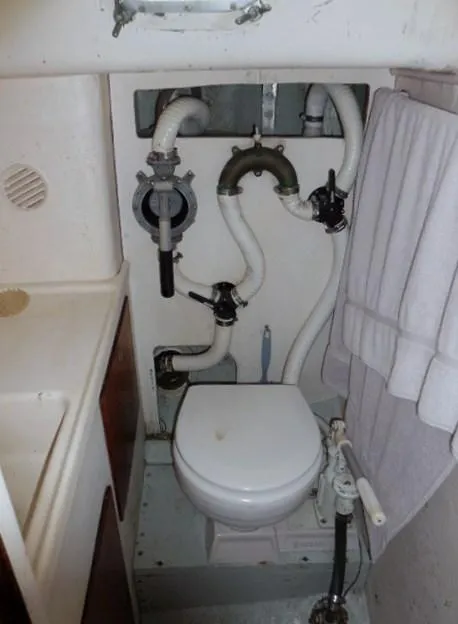Slide: The Image of 1961 Rhodes Swiftsure boat bathroom with white pipes and compact toilet. - 18