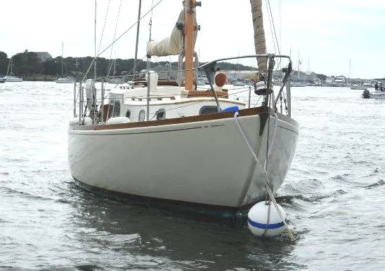 Slide: The Image of 1961 Rhodes Swiftsure sailboat anchored on calm water. - 2