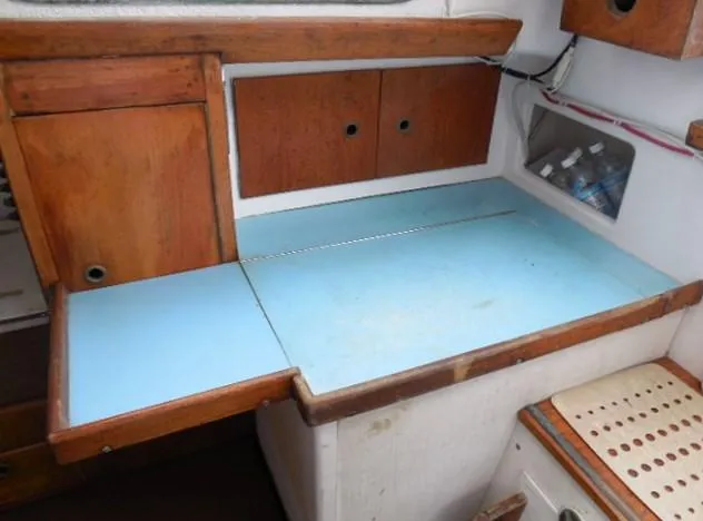 Slide: The Image of 1961 Rhodes Swiftsure boat interior with wooden cabinetry and blue countertop. - 23