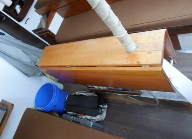 Slide: The Image of Interior of a 1961 Rhodes Swiftsure boat with wooden cabinetry and blue bucket. - 25