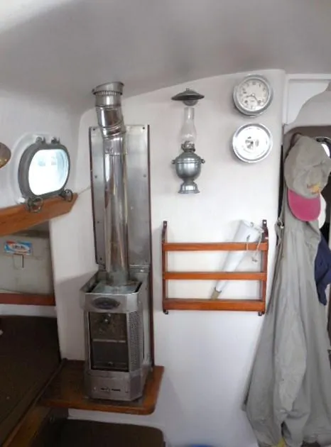 Slide: The Image of Interior of 1961 Rhodes Swiftsure boat with stove, gauges, and hanging coats. - 26