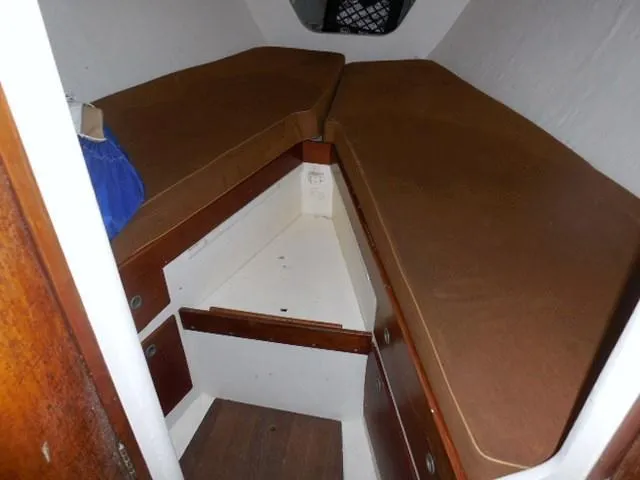 Slide: The Image of Interior cabin of 1961 Rhodes Swiftsure sailboat with brown cushions and storage. - 33