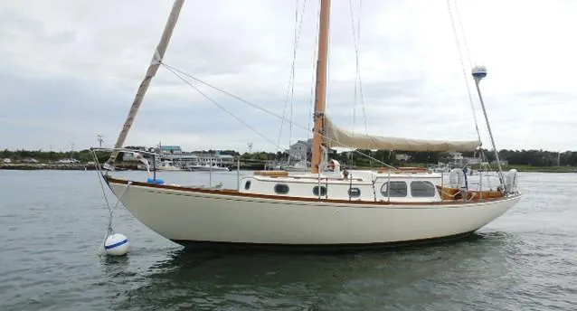 Slide: The Image of 1961 Rhodes Swiftsure sailboat anchored on calm water. - 4