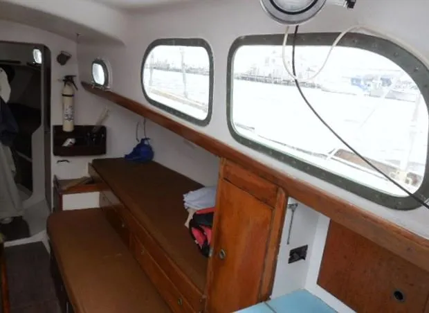 Slide: The Image of Interior of a 1961 Rhodes Swiftsure sailboat with wooden furnishings and porthole windows. - 42