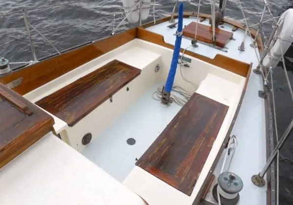 Slide: The Image of 1961 Rhodes Swiftsure sailboat cockpit with wooden benches and nautical equipment. - 43
