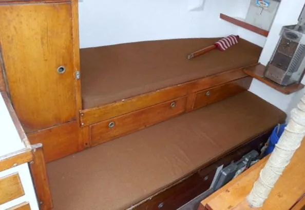 Slide: The Image of Interior of a 1961 Rhodes Swiftsure sailboat with wooden bunks and storage. - 7