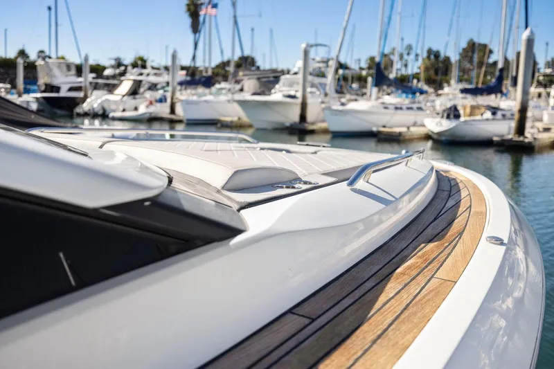 Slide: The Image of 2021 Fairline Fline 33 yacht docked in marina, showcasing sleek design and wooden deck. - 27