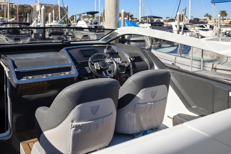 Slide: The Image of 2021 Fairline Fline 33 yacht cockpit with modern steering and controls, docked at marina. - 32