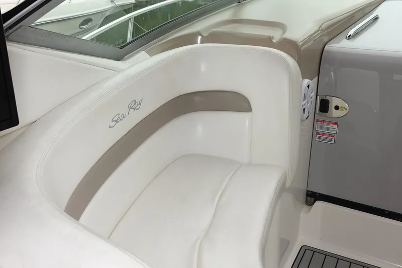 Slide: The Image of 2005 Sea Ray 320 Sundancer interior seating with logo, featuring white and beige upholstery. - 10