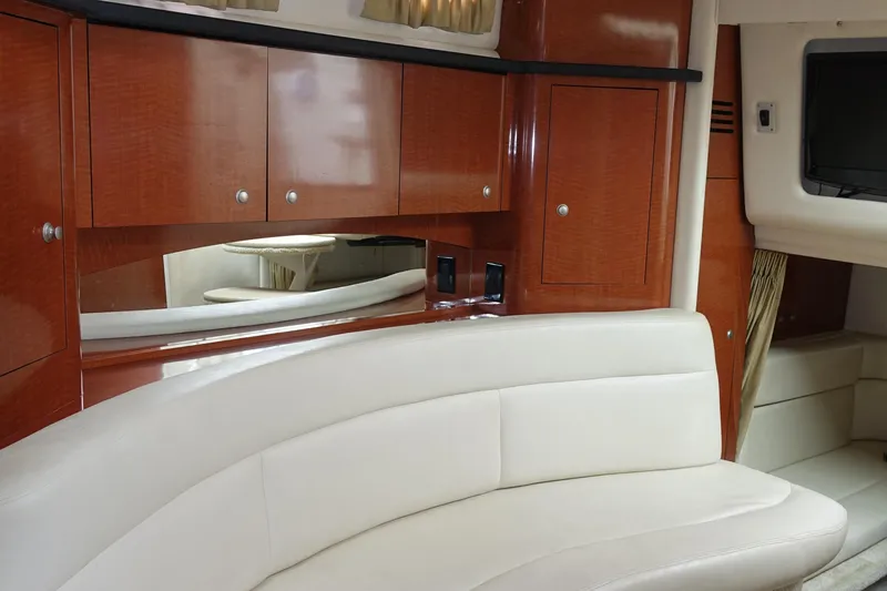Slide: The Image of Luxurious interior of 2005 Sea Ray 320 Sundancer with white leather seating and wooden cabinetry. - 14