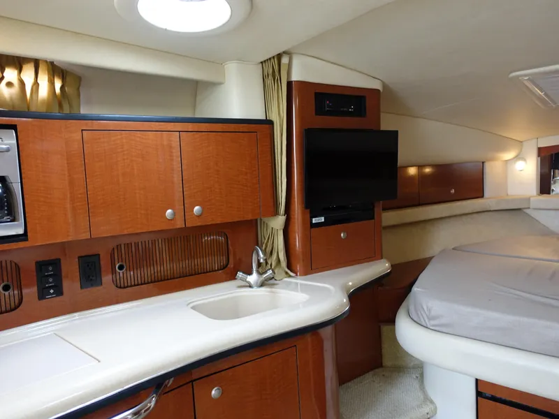 Slide: The Image of 2005 Sea Ray 320 Sundancer cabin with kitchenette, TV, and bed. - 16