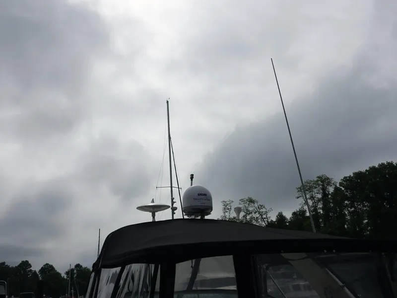 Slide: The Image of Sea Ray 320 Sundancer 2005 boat under cloudy sky with radar equipment. - 2