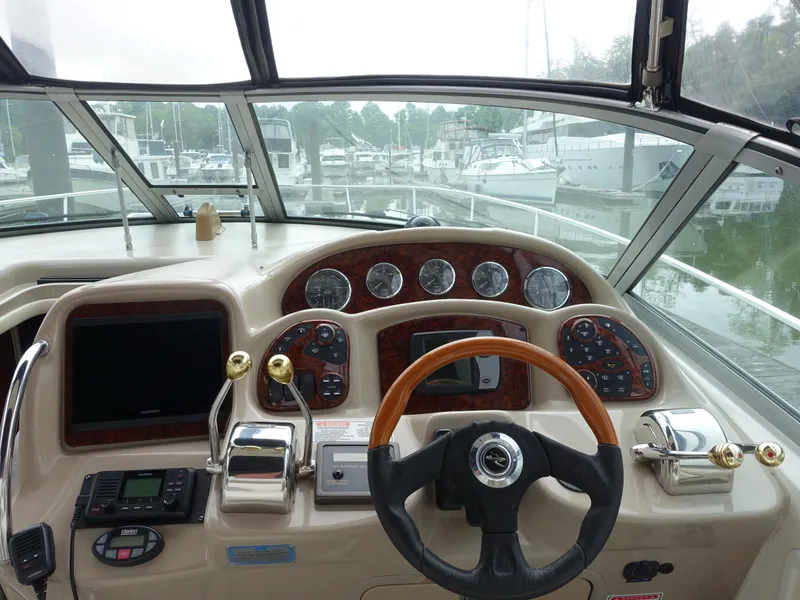 Slide: The Image of Helm of 2005 Sea Ray 320 Sundancer with gauges and controls, docked at marina. - 3