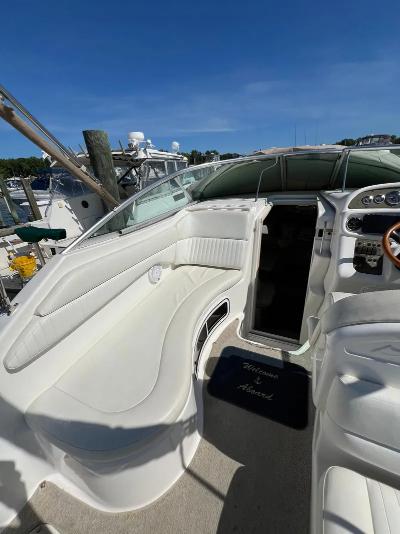 Slide: The Image of Interior of a 2001 Sea Ray 270 Sundancer boat with white seating and dashboard. - 10