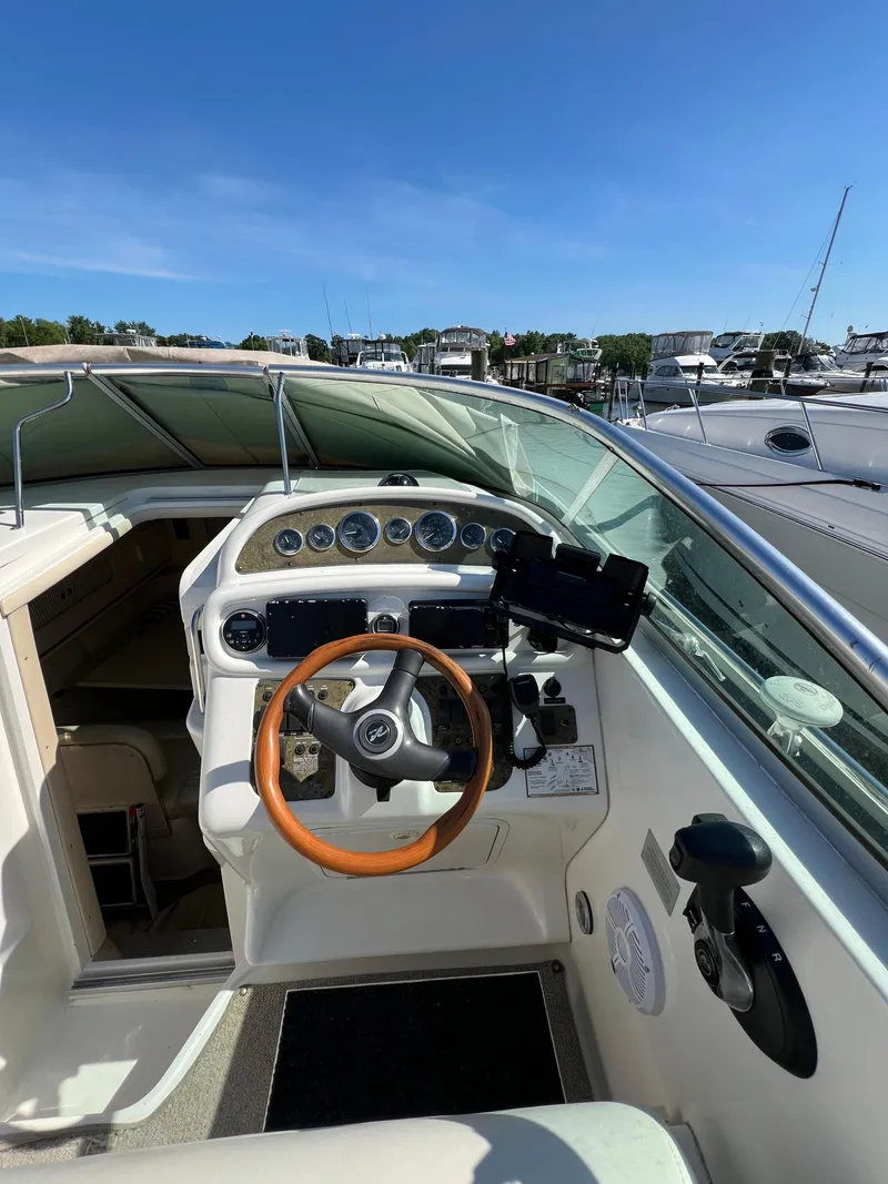 Slide: The Image of 2001 Sea Ray 270 Sundancer boat helm with wooden steering wheel and control panel. - 12