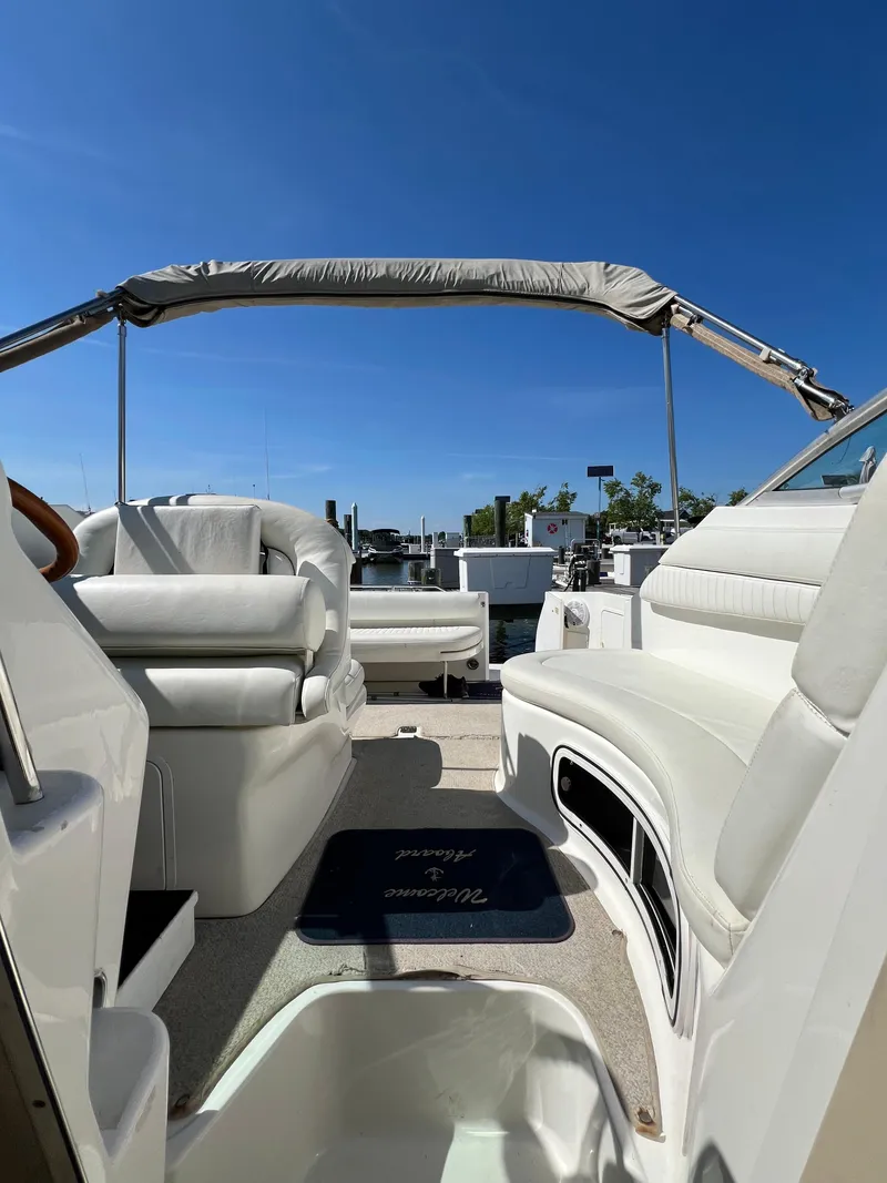 Slide: The Image of 2001 Sea Ray 270 Sundancer boat interior with white seating and blue sky. - 23