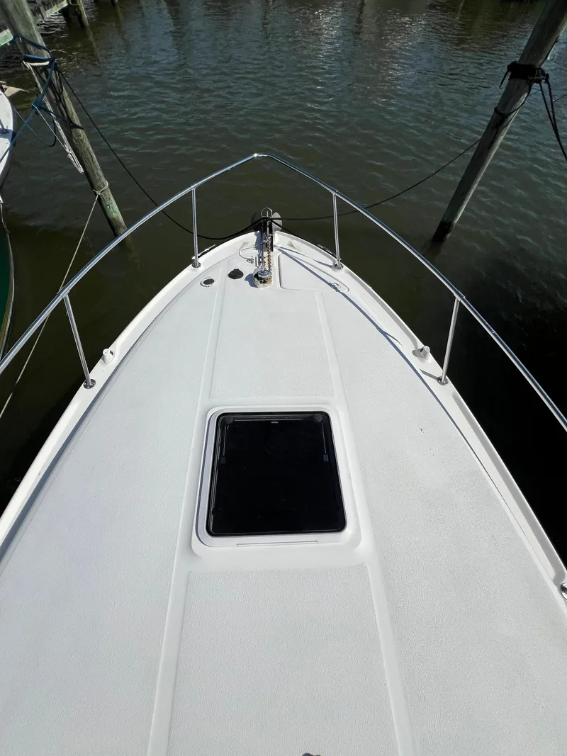 Slide: The Image of Bow of 2001 Sea Ray 270 Sundancer docked, showing deck and water. - 26