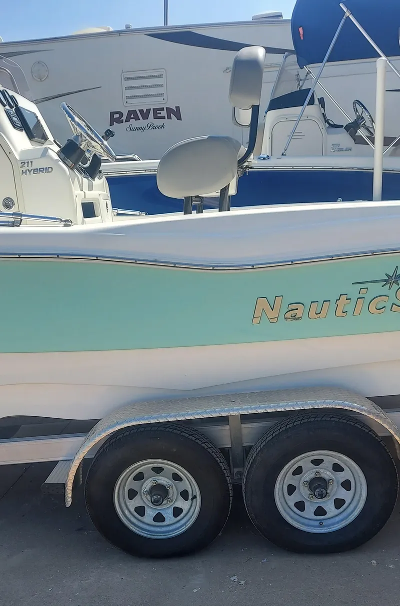 Slide: The Image of 2021 NauticStar 211 Hybrid boat on a trailer, side view. - 12